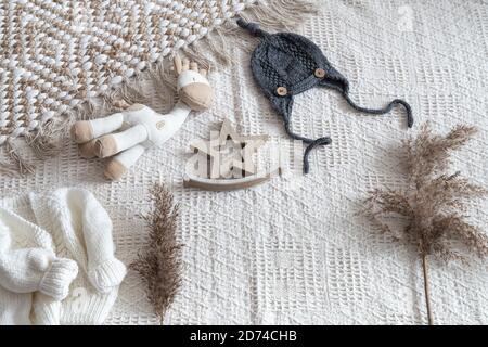 Set di eleganti abiti a maglia fatti a mano per bambini con vari accessori in stile boho, vista dall'alto. Foto Stock