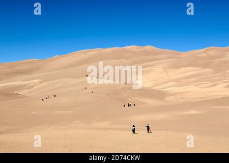 Le persone che camminano nelle dune di sabbia più alte del Nord America. Great Sand Dunes National Park. Montagne Sangre de Cristo in Colorado, Stati Uniti Foto Stock