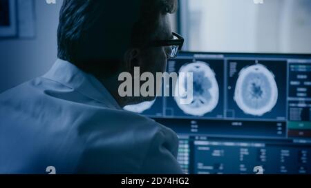 Nel laboratorio medico il paziente viene sottoposto a un processo di scansione RM o TC sotto la supervisione di un radiologo nella sala di controllo, alla procedura di monitoraggio e ai monitor Foto Stock