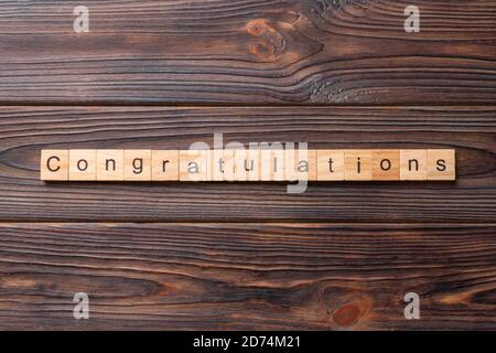 Congratulazioni parola scritta sul blocco di legno. Congratulazioni testo sul tavolo in legno per il desing, concetto. Foto Stock