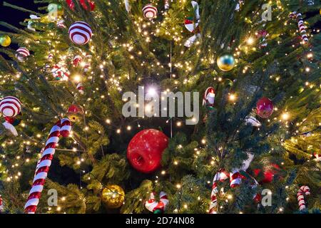 Albero di Natale decorato con ghirlande, caramelle di Natale e diversi baubles. Decorazioni di Capodanno. Primo piano. Foto Stock