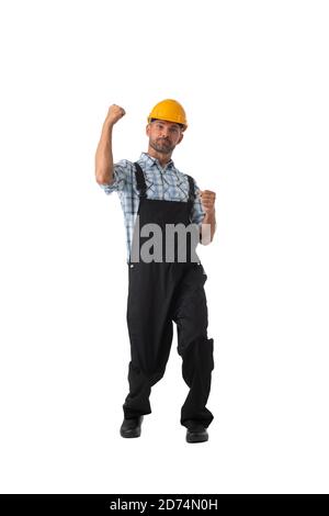 Lavoratore appaltatore maturo in tute e hardhat che tiene pugni isolati su sfondo bianco ritratto studio a lunghezza intera Foto Stock
