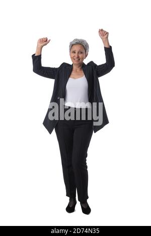 Donna d'affari asiatica matura vincitrice con le braccia sollevate isolato sopra ritratto studio a lunghezza intera su sfondo bianco Foto Stock