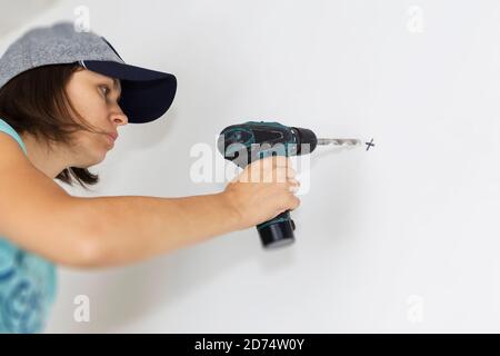 Perforazione di costruttori o lavoratori con una macchina o un trapano. Foto Stock