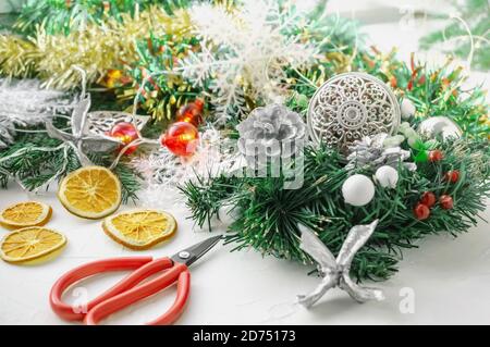 Sulla tavola sono le forbici per fare le decorazioni di Natale dai rami di un albero di Natale. Anno nuovo, concetto di Natale Foto Stock