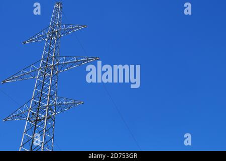 Traliccio di trasmissione dell'elettricità contro il cielo blu. Polo elettrico ad alta tensione su sfondo cielo. Foto Stock