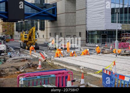 Lavoratori edili che costruiscono binari per la metropolitana West Midlands lungo Broad Street a Birmingham, Regno Unito Foto Stock