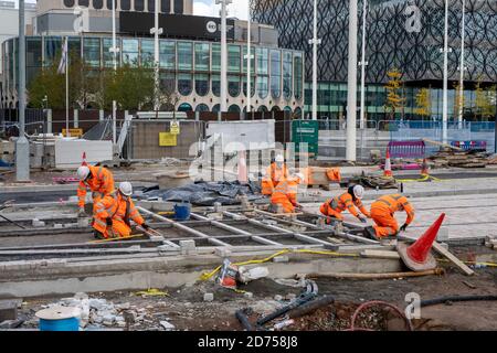 Lavoratori edili che costruiscono binari per la metropolitana West Midlands lungo Broad Street a Birmingham, Regno Unito Foto Stock