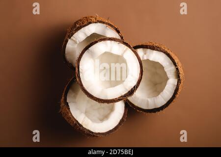 Frutta di cocco su sfondo marrone chiaro, concetto astratto cibo tropicale, vista dall'alto Foto Stock