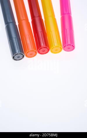 Primo piano di cinque diversi marcatori di colore posizionati accanto a ciascuno di essi altro isolato su sfondo bianco Foto Stock