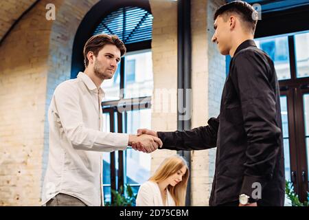 Uomini d'affari si stringono la mano in ufficio Foto Stock