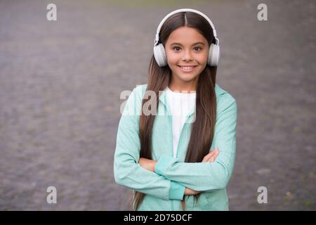 allegro bambino indossare gli auricolari con musica canzone all'aperto godendo melodia, formazione elearning. Foto Stock