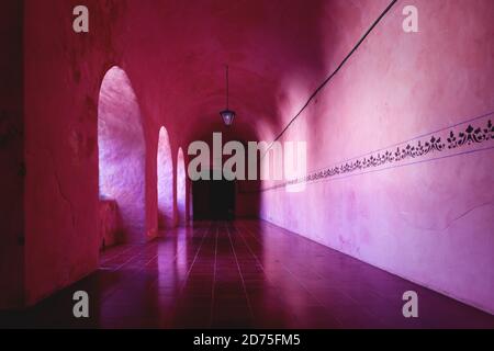 Corridoio di colore arancio rosa con bordo decorativo sulla parete dell'ex Convento monestare di San Bernardino de Siena a Valladolid, Yucatan, Mex Foto Stock