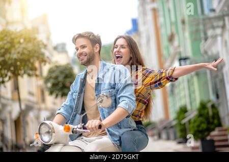 Uomo e donna che si divertano a guidare uno scooter