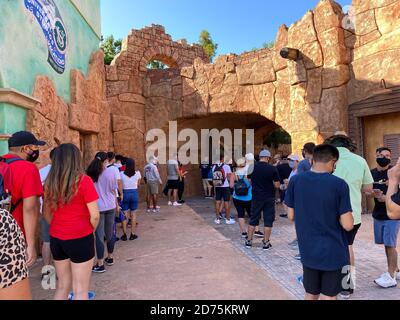 Orlando, FL/USA-10/18/20: Persone che aspettano in fila all'ingresso del biglietto per le isole dell'Avventura agli Universal Studios mentre indossano maschere per il viso An Foto Stock