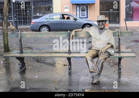 Vista frontale di una statua di un uomo seduto sulla panchina con un piccione a San Juan, Puerto rico. Foto Stock