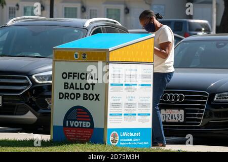 Burbank, California. 26 luglio 2020. Una donna che indossa una maschera facciale fa cadere il suo ballottaggio in una scatola ufficiale di lancio Martedì, Ottobre 20, 2020, in Burbank, California Credit: Ringo Chiu/ZUMA Wire/Alamy Live News Foto Stock