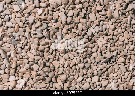 Vista dall'alto della struttura in pietra di ciottoli e dello sfondo. Piccoli ciottoli colorati o pietra. Struttura di pietra. Colore piccolo pavimento rocce sfondo. Arenaria Foto Stock