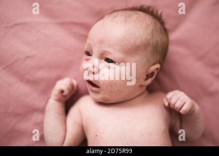 bambina neonato su sfondo rosa a casa Foto Stock