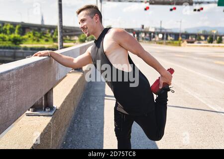 ritratto di un giovane atletico che corre e lavora fuori in città Foto Stock