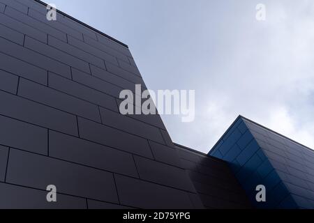 Pareti esterne beige e blu di un moderno edificio d'affari in alluminio con pannelli compositi in metallo oblungo. Foto Stock