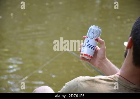 KHARKOV, UCRAINA - 22 2020 AGOSTO: L'uomo detiene la birra alcolica Budweiser Lager durante la pesca. Budweiser è il marchio di Anheuser-Busch Insic più popolare in Foto Stock