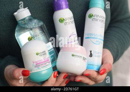 KHARKOV, UCRAINA - OTTOBRE 16 2020: La giovane ragazza detiene i prodotti Garnier. Garnier è un marchio di cosmetici per il mercato di massa dell'azienda francese di cosmetici l'Oreal Foto Stock