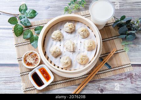 Xiaolongbao al vapore servito in un tradizionale cestino per la cottura a vapore Foto Stock