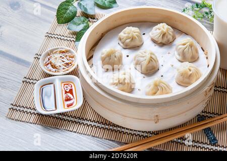 Xiaolongbao al vapore servito in un tradizionale cestino per la cottura a vapore Foto Stock