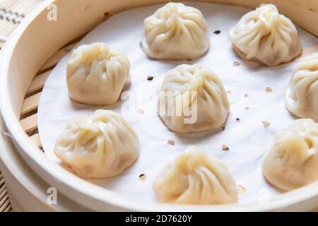 Xiaolongbao al vapore servito in un tradizionale cestino per la cottura a vapore Foto Stock