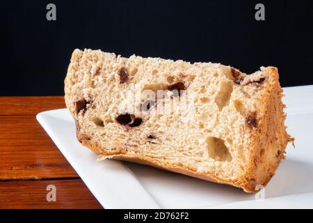 Panettone tradizionale dessert italiano per Natale. Sezioni tagliate con sfondo nero Foto Stock