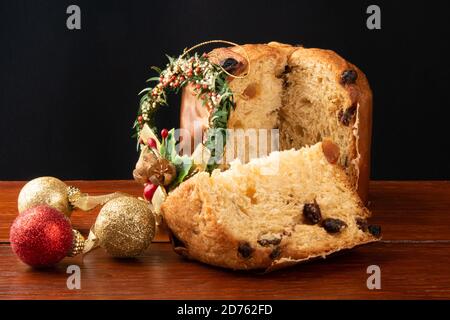 Panettone tradizionale dessert italiano per Natale. Sezioni tagliate con sfondo nero Foto Stock