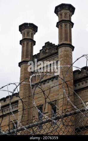 Particolare della recinzione con filo di rasoio e l'imponente facciata della storica prigione Old Joliet, che operò fino al 2002 ed è ora aperto per visite guidate. Foto Stock