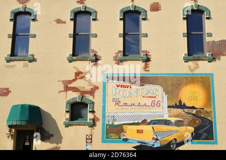 Un murale turistico vecchio stile decora il lato di un edificio storico nella città Route 66 di Pontiac, Illinois. Foto Stock