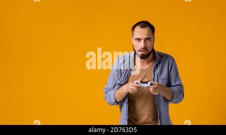 Sono il numero uno nel gioco di giochi primo piano ritratto di divertente gioioso allegro ragazzo felice, è rallegrarsi della sua vittoria con gamepad in mani, isolato su Foto Stock