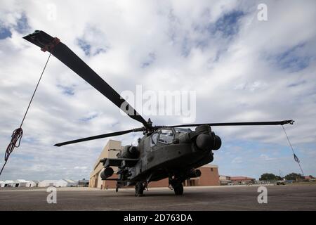 Un elicottero Apache AH-64 si trova all'esterno di un hangar presso l'Hunter Army Airfield, Georgia, ottobre 19, mentre i soldati assegnati alla 3a Brigata dell'aviazione di combattimento, terza divisione di fanteria, conducono la manutenzione sull'aeromobile. I manutentori della terza CABINA assicurarsi che l'attrezzatura rimanga letta per qualsiasi missione che l'unità è chiamata a eseguire. (STATI UNITI Foto dell'esercito di Sgt. Andrew McNeil / 3° Brigata dell'aviazione di combattimento, 3° Divisione Fanteria) Foto Stock