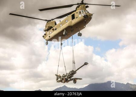 CASERMA DI SCHOFIELD, Hawaii - UNA 25a Divisione di Fanteria CH-47 Chinook trasporta un carico di imbragatura con un Howitzer M777 in preparazione per una dimostrazione di capacità per il Lt. Gen. S K Saini, Vice Capo dello staff dell'esercito indiano sulle caserme di Schofield East Range, Hawaii, il 19 ottobre 2020. Questa visita migliorerà la collaborazione operativa e strategica tra i due eserciti e si costruirà verso un USINDOPACOM libero e aperto Foto Stock