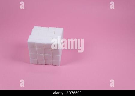 Cubetti di zucchero bianco su fondo rosa composizione. Foto Stock