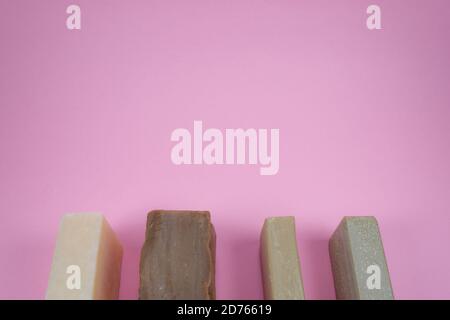 Cinque saponi di colore diverso sulla composizione di sfondo rosa. Foto Stock