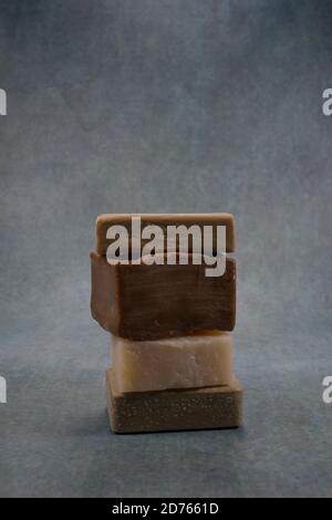 Cinque saponi di colore diversi su composizione di sfondo scuro. Foto Stock