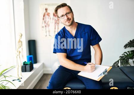Ritratto di un uomo di fisioterapia sorridente in uniforme Foto Stock