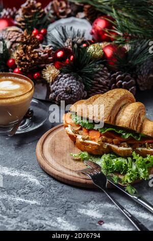Colazione di Capodanno con croissant. Croissant di Capodanno con pesce rosso e avocado. Concetto di Capodanno e Natale Foto Stock
