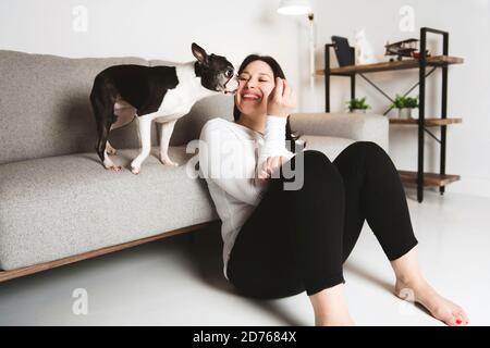 Donna con è Boston Terrier in soggiorno Foto Stock