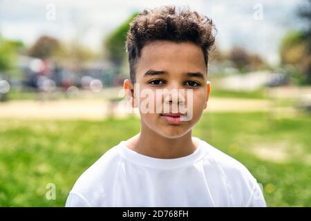 Teen afro americano ragazzo in giardino il giorno ora Foto Stock