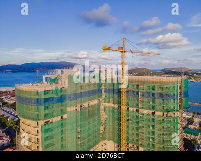 Nuovi edifici in costruzione. Cantiere industriale. Colpo di gru di sollevamento e grattacielo in costruzione Foto Stock