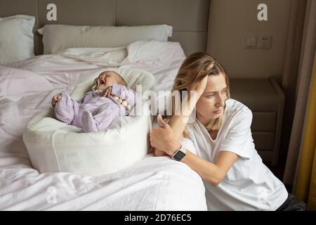 Madre stanca che soffre di depressione postnatale. Salute mamma maternità stressante. Rimani a casa durante il coronavirus covid-19 pandemia Foto Stock