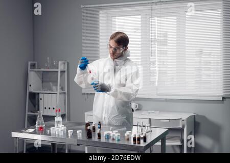 Chimico maschile che svolge una ricerca scientifica nel suo laboratorio. Foto Stock