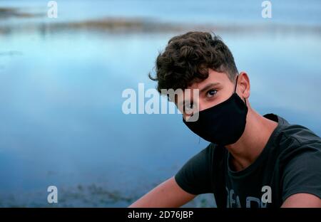 Giovane uomo caucasico che indossa una maschera nera Foto Stock