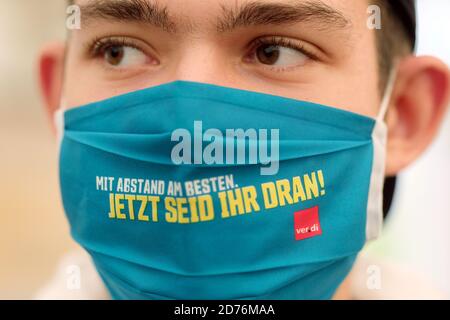 Lipsia, Germania. 21 Ott 2020. Un partecipante in un colpo simbolico da parte del sindacato di servizi Verdi indossa una maschera di bocca e naso con le parole 'di gran lunga il meglio. Ora tocca a te!". Verdi richiede il 4.8% in più di retribuzione per i dipendenti. Credit: Sebastian Willnow/dpa-Zentralbild/dpa/Alamy Live News Foto Stock