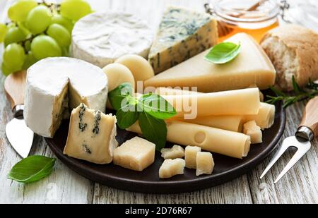 Vari tipi di formaggio su sfondo bianco di legno Foto Stock